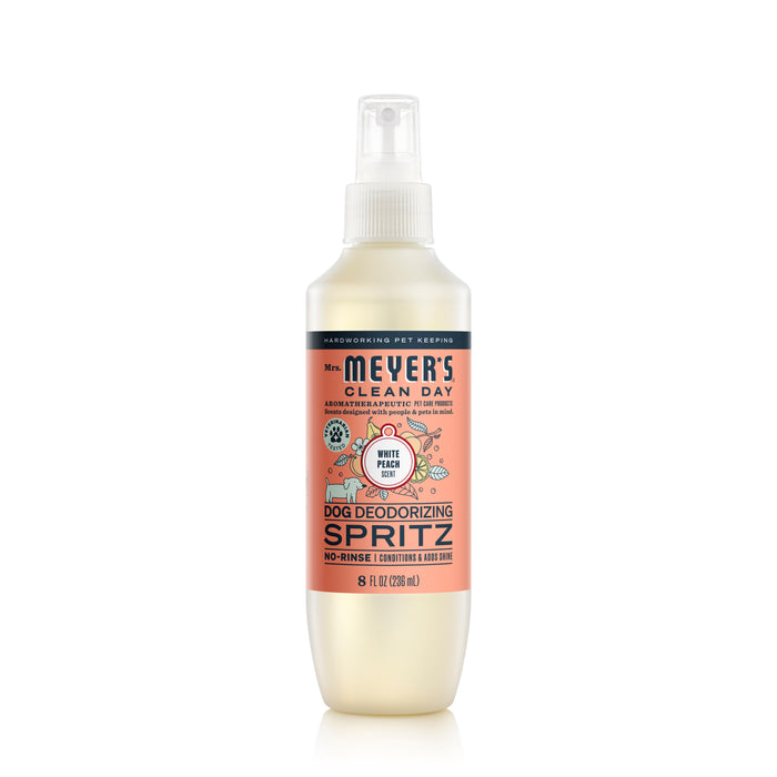 Mrs. Meyers Dog No-Rinse Shampoo in a sleek white bottle with pink and silver labels enhances your dogs coat with a white peach scent and shine, featuring stylish dog care graphics.
