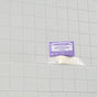 Dr. Bronners Pure-Castile Bar Soap with a calming lavender scent and hemp seed oil, wrapped in a purple label, sits on a tiled shower ledge against a light gray grid-patterned wall.