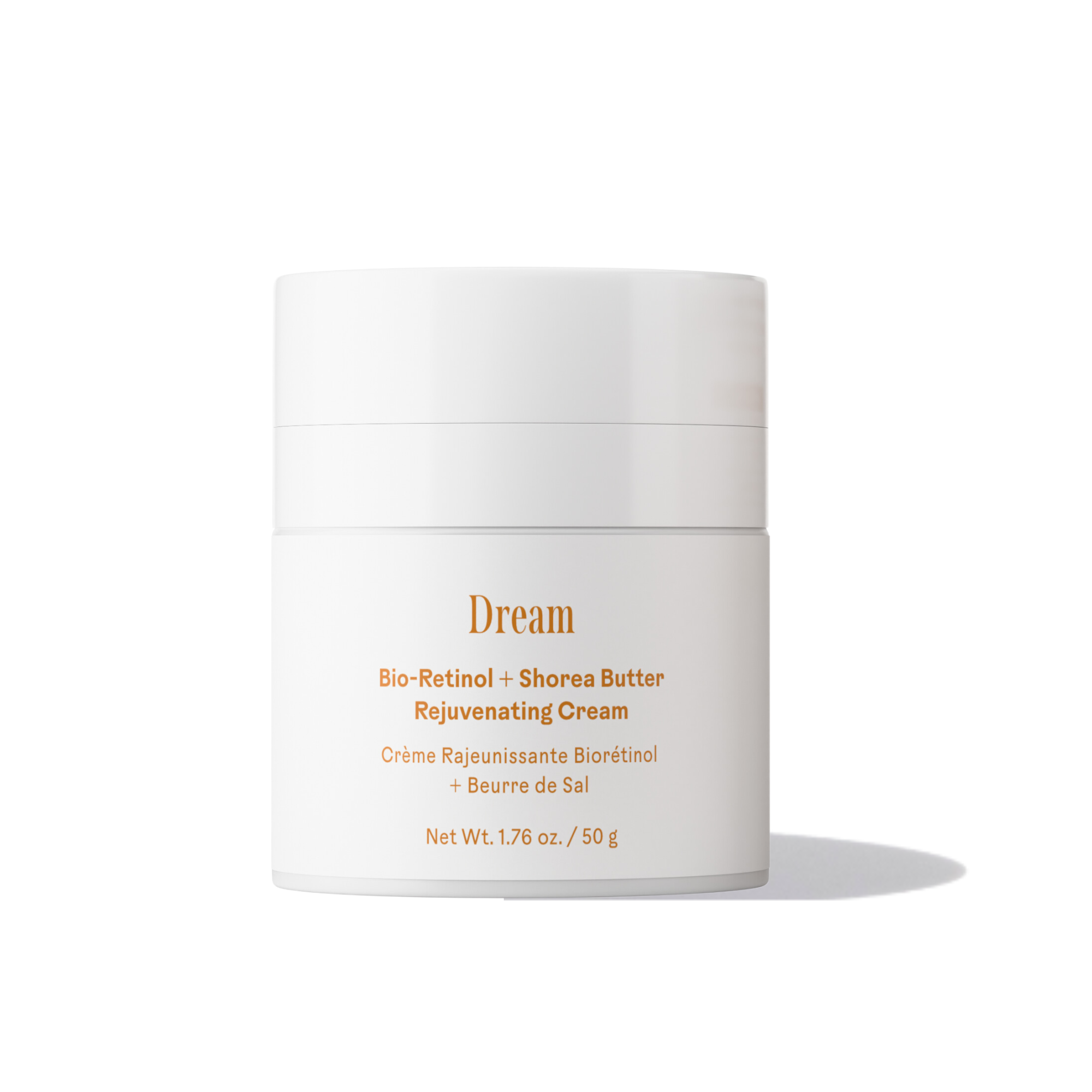 A white jar of Three Ships Dream Bio-Retinol + Shorea Butter Rejuvenating Cream with gold and orange text sits on a white background with a soft right shadow—ideal for overnight skin hydration.