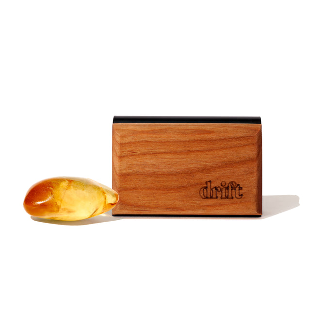 The Drift Single Wood Car Air Freshener Starter Kit features a polished, sustainably sourced wooden block engraved with drift, paired with an amber-hued, oval stone, both set against a clean white background.