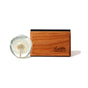 A clear resin sphere with a dandelion puff rests beside the Drift Single Wood Car Air Freshener Starter Kit, which features sustainably sourced wood and an engraved Drift logo, displayed on a white background.