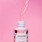 A dropper dispenses a clear liquid into a pink bottle labeled Everyday For Future Moisturizing Face Serum with Hyaluronic Acid for dry skin, delivering a hydrating boost against a pink background.