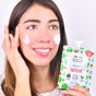 With a smile, they apply the creamy Hydrating Watermelon Face Mask from Everyday For Future to their cheeks, holding the colorful, vegan skincare packet in their left hand. The mask features natural ingredients against a plain white background.