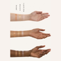 Three forearms with varying skin tones display swatches of Ember Wellness The Complete Minibar Set in Bronze, Sunstone, and Rose Quartz shades from wrist to forearm.