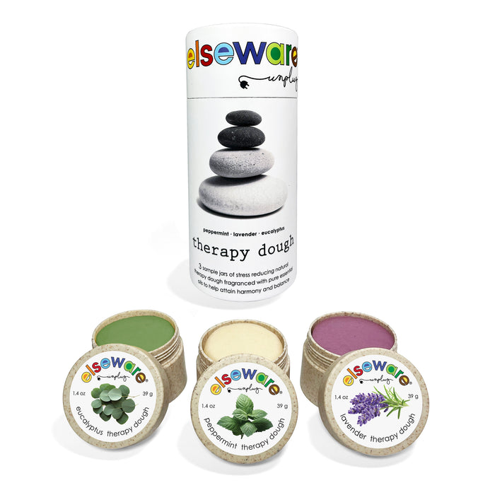A cylindrical Elseware Unplug Therapy Dough Sampler with Aromatherapy is shown beside three small open jars—green (peppermint), cream (eucalyptus), and purple (lavender)—for a relaxing sensory experience.