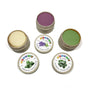 Three small jars from the Elseware Unplug Therapy Dough Sampler with Aromatherapy reveal purple, cream, and green doughs. Lids show lavender, peppermint, and eucalyptus scents for a soothing, stress-relieving sensory experience.