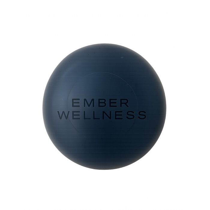 The Charcoal Exfoliating Cleanser Bar by Ember Wellness is a dark blue, round bar with EMBER WELLNESS printed in black, photographed on a white background—ideal for gentle exfoliation and suitable for sensitive skin.