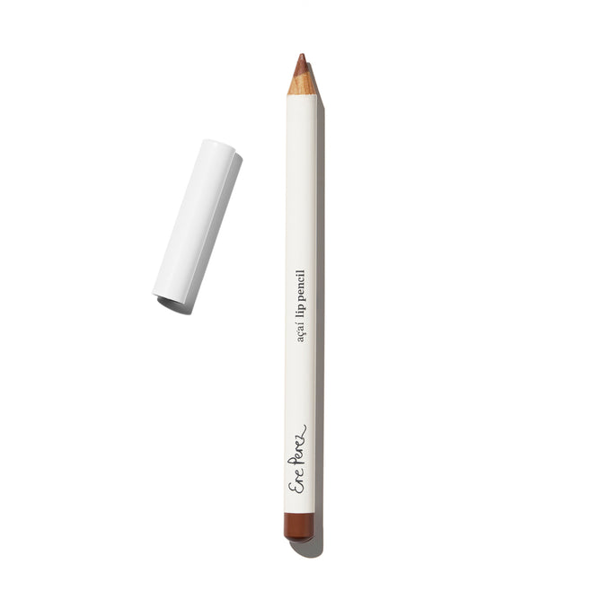 An Ere Perez Acai Lip Pencil with a white body, brown tip, black “Acai Lip Pencil” text, and a white cap lies on a white surface.
