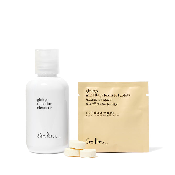 A white bottle of Ere Perez Ginkgo Micellar Cleanser and a beige packet of matching cleansing tablets, with three round tablets in front—ideal for those wanting a gentle cleanser for sensitive skin.