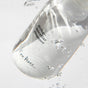 A clear Ere Perez Ginkgo Micellar Cleanser bottle floats underwater with small air bubbles, evoking the refreshing purity of a gentle cleanser for sensitive skin, set against a light background.