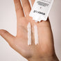 A hand holds two lines of concentrated conditioner from a sachet labeled Everist The Deep Conditioning Concentrate Sample—a sustainable, innovative haircare product.