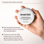 A hand holds a round container of Everist The Fragrance-Free Shampoo Concentrate, a dermatologist-tested, hypoallergenic formula with over 50% moisturizers, ideal for sensitive scalps.
