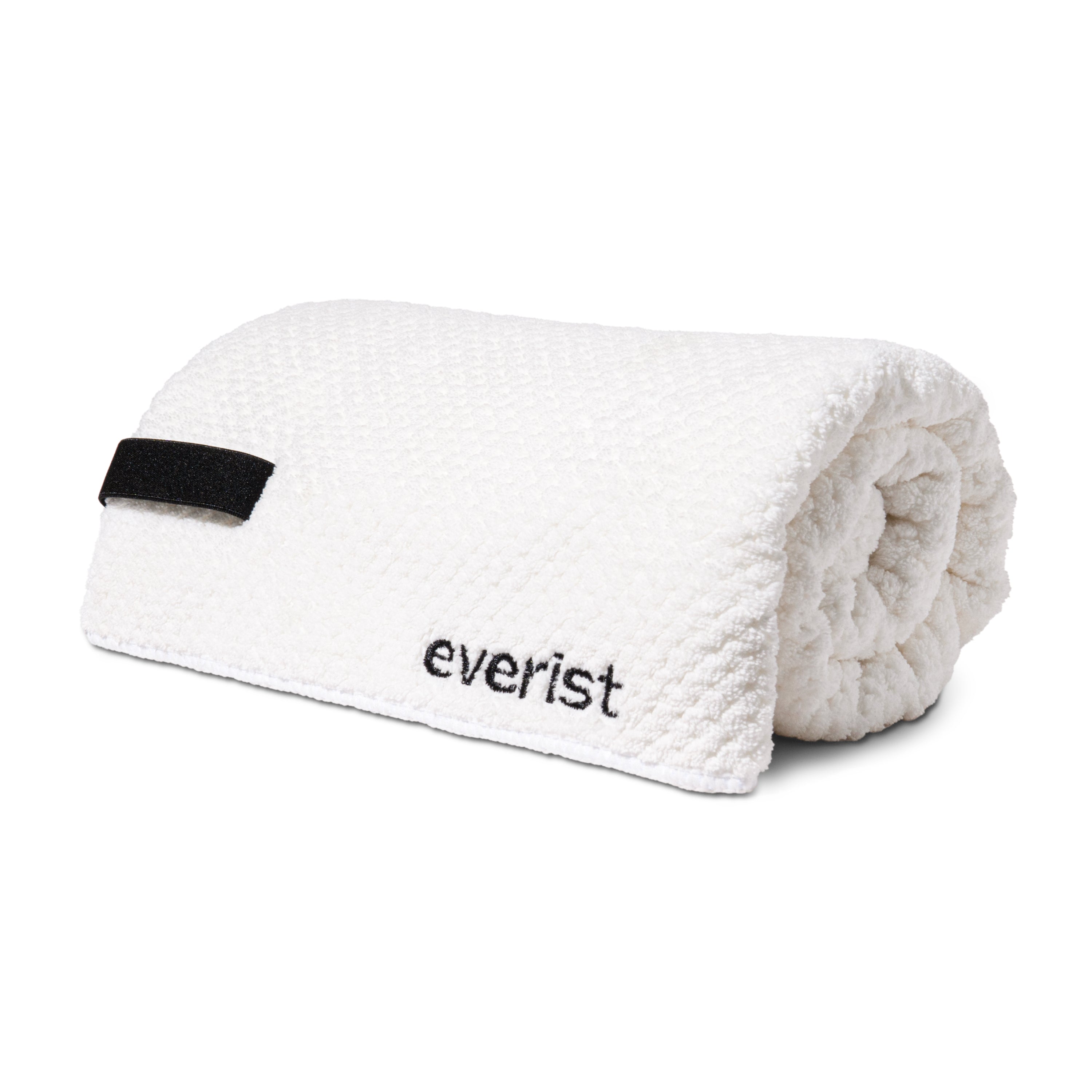 The Quick-Dry Hair Towel by Everist is a white textured microfiber towel with a black loop and everist embroidery. Designed to reduce frizz, its both stylish and functional.