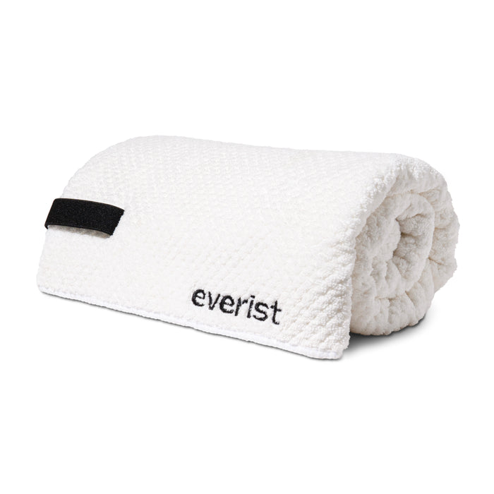 The Quick-Dry Hair Towel by Everist is a white textured microfiber towel with a black loop and everist embroidery. Designed to reduce frizz, its both stylish and functional.
