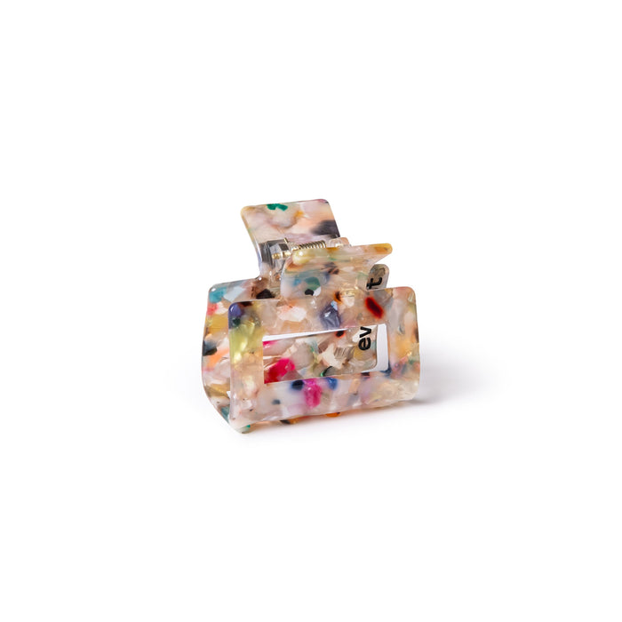 The Small Confetti Claw Clip by Everist is made from translucent resin with colorful confetti patterns and a visible metal spring. This gentle clip is ideal for daily styling, shown on a plain white background.
