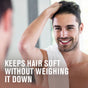 A smiling man with short dark hair stands by a mirror, touching his head with a white towel on his shoulder. Text reads: Every Man Jack 2-in-1 Shampoo and Conditioner for Men—keeps hair soft without weighing it down.