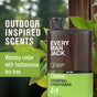 A bottle of Every Man Jack 2-in-1 Shampoo + Conditioner, tea tree scent, stands before green leaves. Text: Outdoor inspired scents—woodsy cedar and herbaceous tea tree. Strengthens with Wheat Protein.