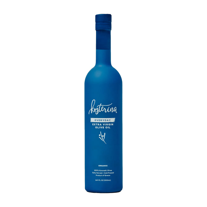 A tall, matte blue bottle of Kosterina Organic Everyday Extra Virgin Olive Oil stands upright, featuring a white label with text and an olive branch illustration. The bottle is topped with a matching blue cap.