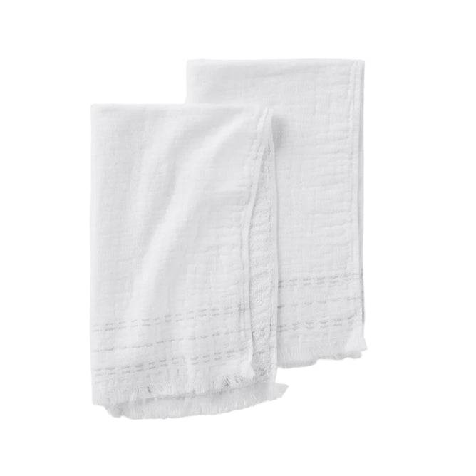 Set of two white Alder Organic Hand Towels by Coyuchi, featuring a subtle stitched pattern and frayed edges with a delicate gauze texture, shown against a white background.