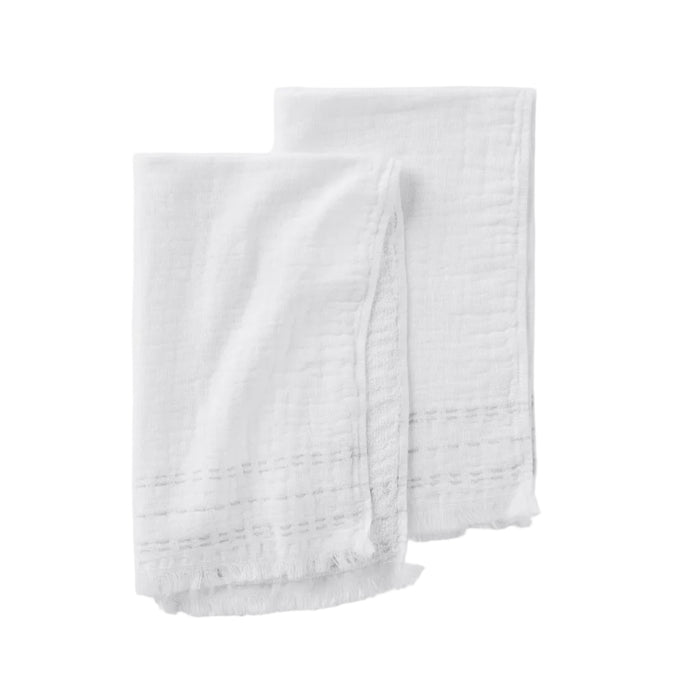 Set of two white Alder Organic Hand Towels by Coyuchi, featuring a subtle stitched pattern and frayed edges with a delicate gauze texture, shown against a white background.