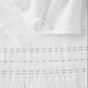A close-up of the Coyuchi Alder Organic Hand Towels, Set of 2, showcases white artisanal cotton towels with a gauze texture and fringed edges, neatly layered atop one another.