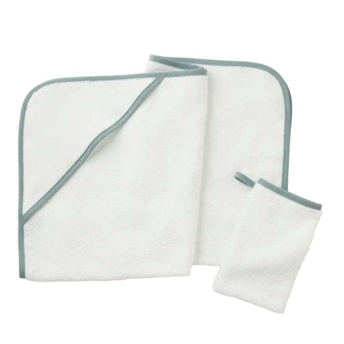 A folded white towel with green trim, an unfolded matching towel, and a small matching washcloth—expertly crafted from soft Turkish cotton—are displayed on a white background. Shown here is the Cloud Loom™ Organic Baby Hooded Towel and Bath Mitt Set by Coyuchi, designed for gentle, soothing care.