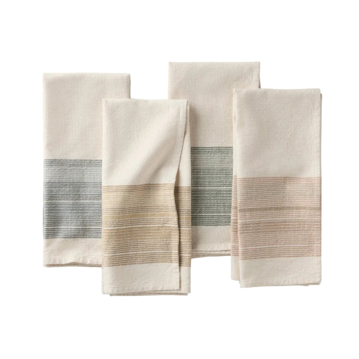 Four folded organic kitchen towels with woven stripe accents in blue, tan, green, and blush pink, arranged on a white background. These absorbent cotton towels are yarn dyed for rich, lasting color and effortless style in your kitchen.