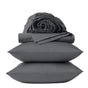 A set of dark gray bedding from Coyuchi’s Classic Organic Sateen Sheet Set, featuring two stacked pillows, a folded flat sheet, and a rolled fitted sheet, all neatly presented against a plain light background. Made from GOTS certified organic cotton, this collection delivers breathable comfort with superior eco-friendly quality.