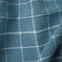 Close-up of draped blue fabric with a white grid check pattern, highlighting soft folds and a textured woven surface—crafted from Coyuchi’s Clarendon Organic Kitchen Towels, Set of 4, for an eco-friendly touch.