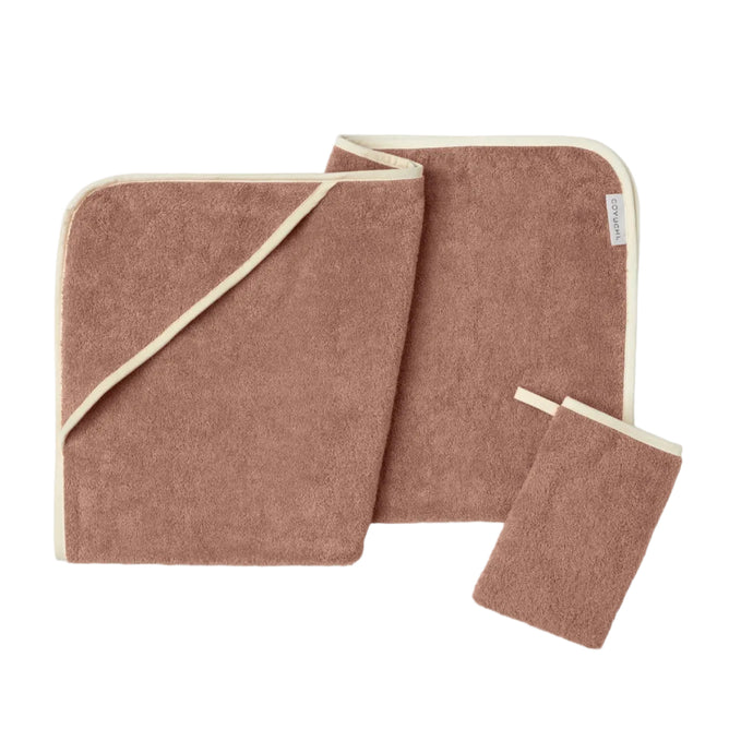 The Coyuchi Cloud Loom™ Organic Baby Hooded Towel and Bath Mitt Set, crafted from soft brown Turkish cotton with cream trim, features a folded hooded towel, a flat towel, and a small wash mitt with a loop—all shown against a white background.