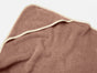 The Cloud Loom™ Organic Baby Hooded Towel and Bath Mitt Set by Coyuchi, crafted from luxurious Turkish cotton in a warm brown hue with cream-colored trim, is displayed on a light background. The towel looks exceptionally soft, featuring gentle folds and a slightly wrinkled texture.