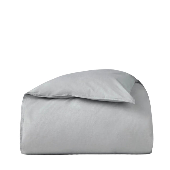 The Coyuchi Organic Crinkled Percale™ Duvet Cover, shown neatly folded in light gray with its signature crinkled percale texture against a plain white background, is ideal for those seeking breathable bedding.