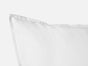 A close-up of the Coyuchi Organic Crinkled Percale™ Sham, featuring a crisp, clean cover crafted from GOTS certified cotton, set against a plain white background. The image highlights the sham’s corner and edge, subtly showcasing the soft crinkled texture of its organic percale weave.