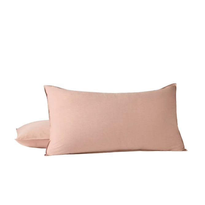 Two light pink rectangular pillows are stacked on a flat surface, with one standing upright in front of the other against a plain white background. Designed for comfort, these pillows pair beautifully with breathable bedding or can be styled with the Coyuchi Organic Crinkled Percale™ Sham for a relaxed yet elegant look.