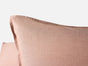 Close-up of the Coyuchi Organic Crinkled Percale™ Sham in light pink, featuring visible edge stitching and set against a plain light background.