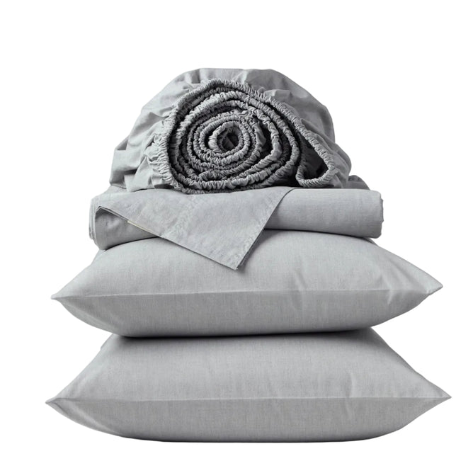 A neatly stacked set of Coyuchi’s Organic Crinkled Percale™ Sheet Set in light gray—including two pillows, a folded sheet, and a rolled fitted sheet—offers a breathable bedding experience and is displayed against a plain white background.