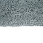 Close-up of the edge of the Shag Organic Bath Rug by Coyuchi, featuring dense, soft textured fibers in a fluffy, light gray shag design, set against a plain white background. Its quick-drying properties make it as practical as it is comfortable.