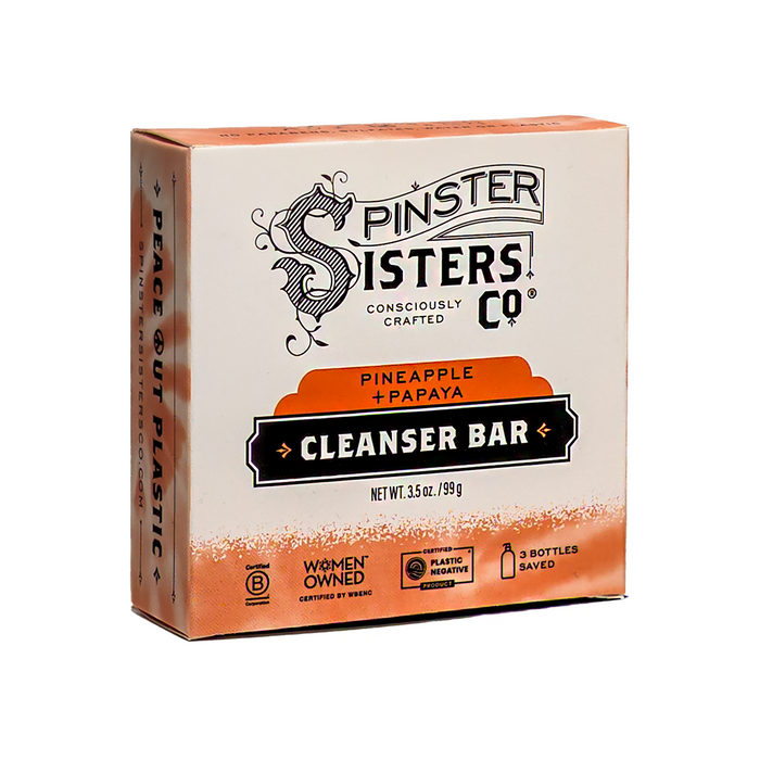 A box of Spinster Sisters Co. Vegan Daily Glow Face Cleanser Bar – Pineapple and Papaya for acne-prone skin, featuring eco-friendly icons, women-owned and plastic-negative certifications, plus a Peace Out Plastic message on the side.