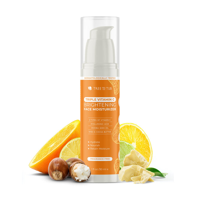 A bottle of Tree To Tub Brightening Face Moisturizer - Triple Vitamin C is shown with orange slices, a lemon wedge, shea butter, and macadamia nuts to highlight its natural ingredients and anti-aging benefits.