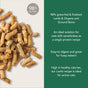 Close-up of brown, pellet-like Feline Natural Grain-Free, Freeze-Dried Cat Food on a beige background, highlighting that it's made with 98% real meat, grass-fed lamb, organ, and bone—ideal for sensitive and active cats.