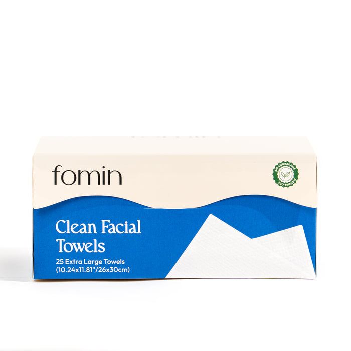 A rectangular Fomin Clean Facial Towels box features blue and white packaging with a green seal on the top right. Contains 25 extra large disposable face towels for sensitive skin. Product dimensions are included on the packaging.