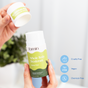 A hand opens a Fomin Deodorant Stick labeled Honey Pear, emphasizing its eco-conscious, aluminum-free, cruelty-free, vegan, and chemical-free formula. A blurred plant is seen in the background.