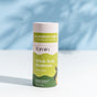 A Fomin Deodorant Stick in Honey Pear stands upright on a white surface. The eco-friendly, aluminum-free deodorant neutralizes odors naturally. A light blue background complements its green and white label.