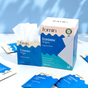 A box labeled Fomin Feminine Wipes sits on a white surface, with an open packet revealing textured wipes. Several individual packets are scattered around the blue and white packaging, designed to support vaginal pH balance.