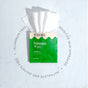 A green and white Fomin Feminine Wipes packet sits on a light surface, several wipes partially pulled out. Circular text highlights gentle cleansing, aluminum-free, sensitive skin approved, and more.
