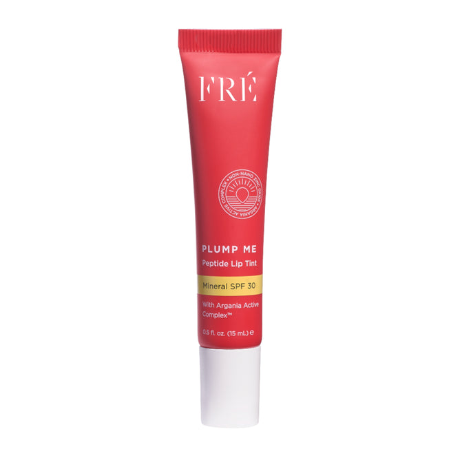 A red tube of FRÉ Skincare PLUMP ME Peptide Lip Tint Mineral SPF 30 with a white cap; features Argania Active Complex, lip plumping benefits, and comes in a 0.5 fl. oz. (15 mL) size.
