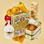 A vibrant package of Fishwife Mussels with Sweet Pepper & Garlic sits beside an open tin of mussels, cherry tomatoes, yellow pepper, garlic bulbs, and crackers displayed on a reflective golden surface.