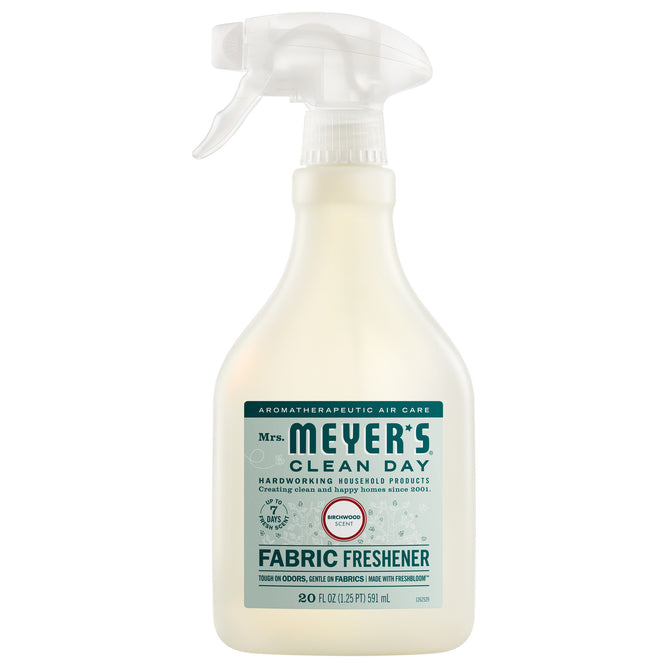 Mrs. Meyer's Fabric Freshener Spray in Honeysuckle scent offers a long-lasting, odor-fighting formula. The cream bottle has a white nozzle, with the label showing product and usage details.