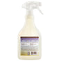 A clear spray bottle with a white trigger and a purple back label displays product info for Mrs. Meyer's Fabric Freshener Spray, including directions, ingredients, odor-fighting benefits, and recycling instructions.