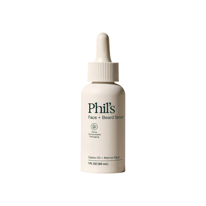 A white dropper bottle labeled Phil's Face and Beard Serum sits on a plain white background, featuring castor oil, marine algae, compostable packaging symbol, and showing its 1 fl oz (30 mL) size.